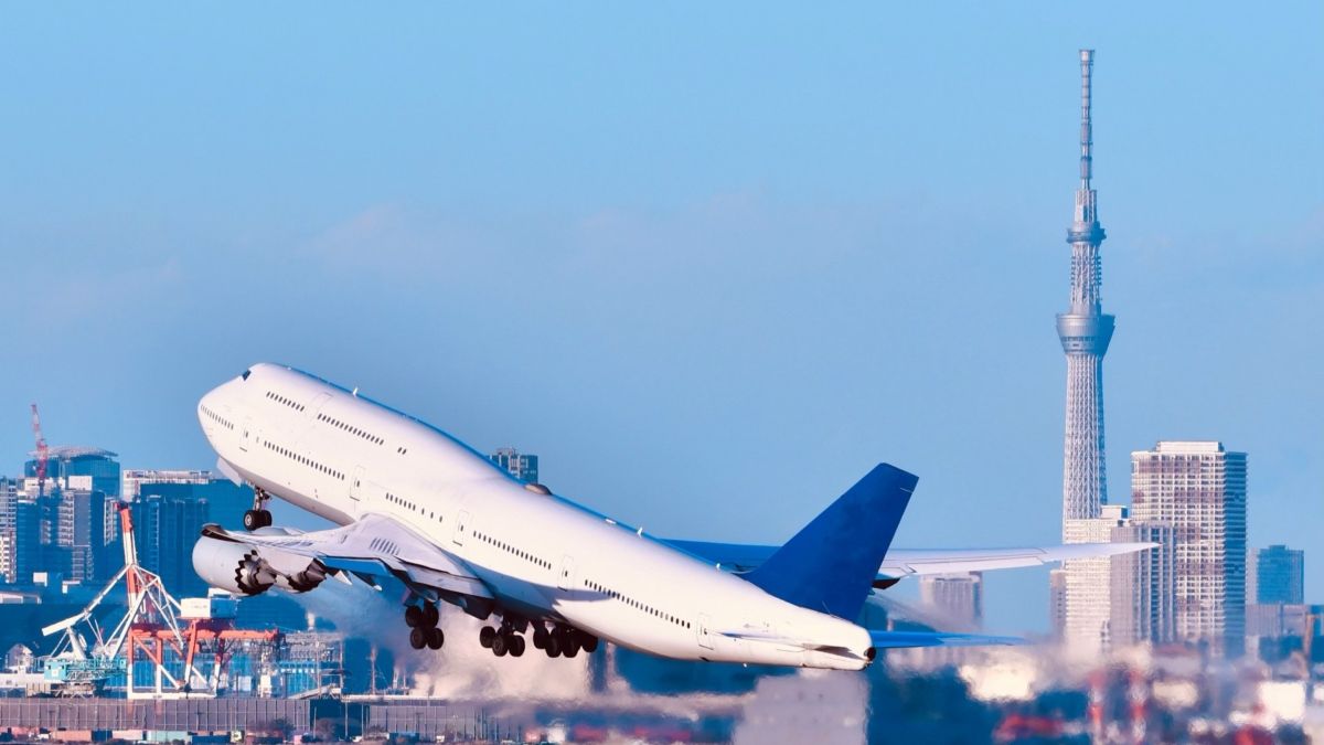 羽田空港から飛び立つ飛行機と東京スカイツリー